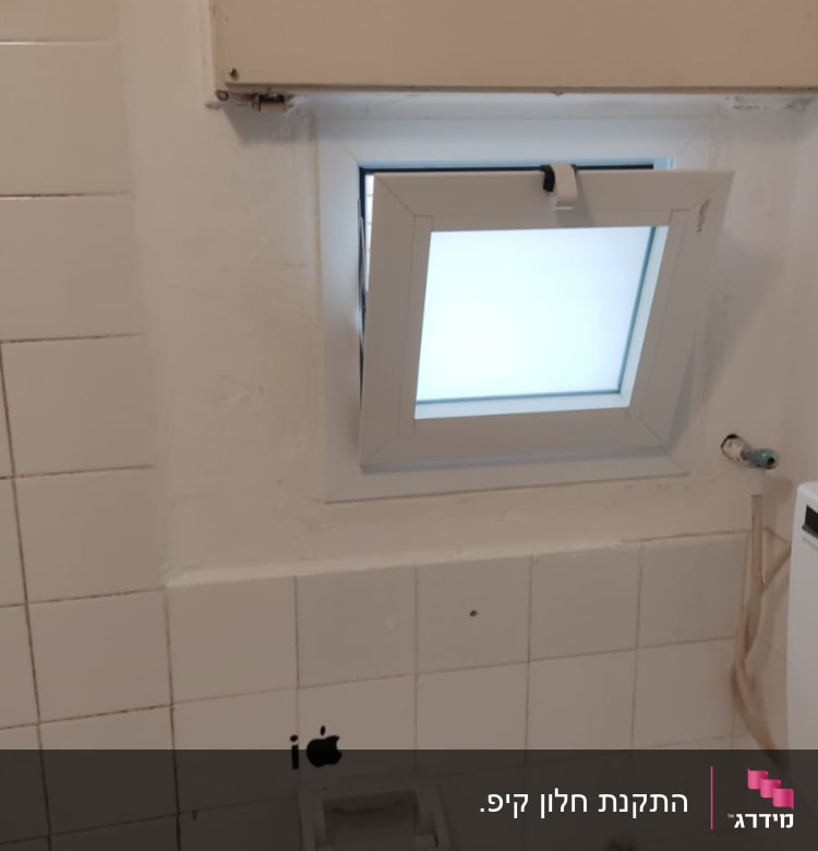 חלון אלומיניום קטן פתוח בקיר לבן